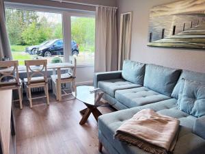 ein Wohnzimmer mit einem blauen Sofa und einem Tisch in der Unterkunft Idyllische Ferienwohnung Schmidt 9226 - Burg in Fehmarn