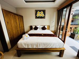 ein Schlafzimmer mit einem großen Bett mit weißer Bettwäsche in der Unterkunft Cecillia Guesthouse Canggu in Canggu