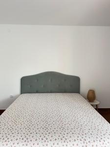 a bedroom with a bed with a green headboard at Surčin Apartment in Ledine
