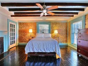 um quarto com uma cama e uma ventoinha de tecto em Diplomat House em Savannah