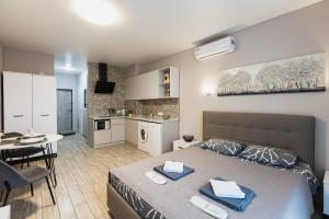a bedroom with a bed and a table and a kitchen at Aura Home in Dnipro