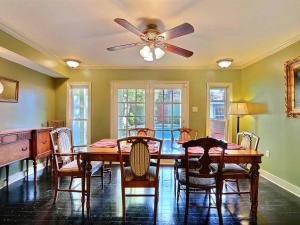 uma sala de jantar com uma ventoinha de tecto, uma mesa e cadeiras em Diplomat House em Savannah