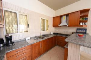 a kitchen with wooden cabinets and a sink at Santa Maria Main Street in Santa Maria