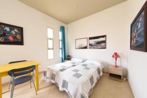 a bedroom with a bed and a table and a desk at Santa Maria Main Street in Santa Maria