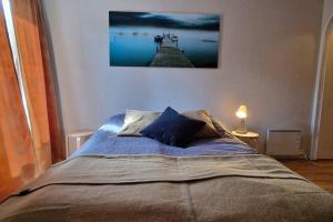 a bed in a bedroom with a picture on the wall at Central apartment with a view! in Harstad