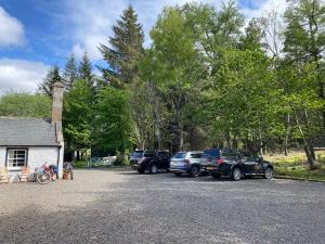 um grupo de carros estacionados em frente a uma casa em Forsinard Lodge em Forsinard