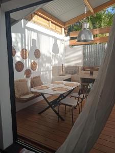 a patio with a table and chairs on a deck at Yaka in Saint-Paul