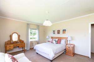 1 dormitorio con cama blanca y espejo en Lowestoffe Country Lodge Rockford en Hogsback