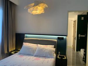 a bedroom with a bed with a blue headboard at lmperio Residence Melaka - Private Indoor Hot Jacuzzi in Melaka