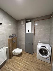 a bathroom with a toilet and a washing machine at Apartamenty Kalisz Pomorski in Kalisz Pomorski