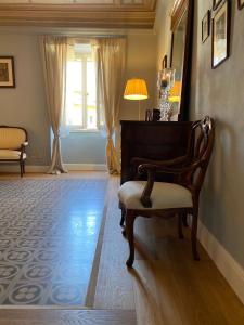 een woonkamer met een stoel en een spiegel bij Burlamacchi Villas in Bagni di Lucca