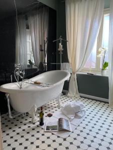 uma casa de banho com banheira e um livro no chão em Burlamacchi Villas em Bagni di Lucca