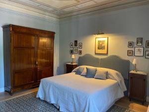 1 dormitorio con 1 cama grande y armario de madera en Burlamacchi Villas, en Bagni di Lucca