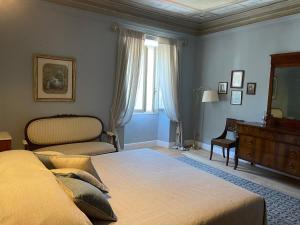 a bedroom with a bed and a dresser and a window at Burlamacchi Villas in Bagni di Lucca