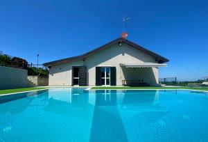 a house with a swimming pool in front of a building at VILLA GIOIA - Piscina nel Monferrato in Pecetto di Valenza