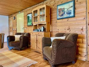 a living room with two chairs and a wooden wall at Laimjala Guesthouse with a Cozy Lounge and Terrace in Kurdla