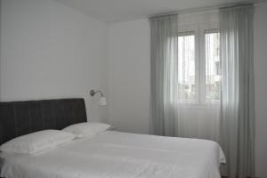 1 dormitorio con cama blanca y ventana en Apartment Aria Split en Split