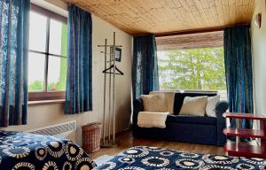 1 dormitorio con sofá azul y ventana en Laimjala Guesthouse with a Cozy Lounge and Terrace en Kurdla