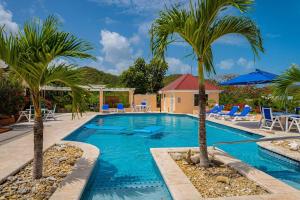 een zwembad met palmbomen in een resort bij Beach Villa in Five Islands Village