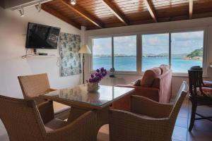 a living room with a table and chairs with a view of the ocean at Beach Villa in Five Islands Village