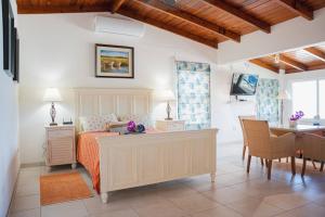 a bedroom with a bed and a table and a desk at Beach Villa in Five Islands Village