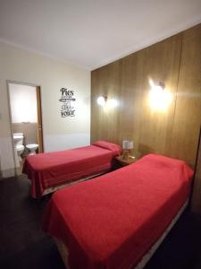 2 camas en una habitación de hotel con sábanas rojas en Hotel Lobo de Mar - Centro en Mar del Plata