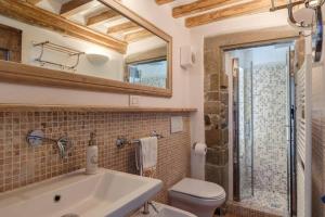 een badkamer met een wastafel, een toilet en een spiegel bij La Finestrella in Cortona