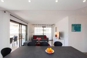 una sala de estar con una mesa con un bol de fruta. en 2-bedroom 2 min from the beaches with a terrace, en Cannes