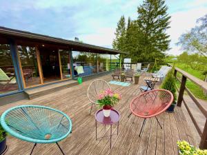 drie stoelen en een tafel met bloemen op een terras bij Laimjala Guesthouse with a Cozy Lounge and Terrace in Kurdla