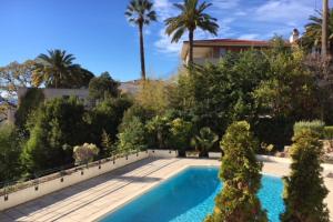 a swimming pool in a yard with palm trees at PERFECT 3 bedrooms with terrace & pool in Cannes