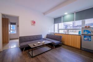 een woonkamer met een bank en een tafel bij Zuka Hotel & Apartment in Da Nang