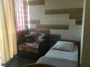Cette chambre comprend un canapé, une chaise et un lit. dans l'établissement Inn Alibi, à Khorodelets