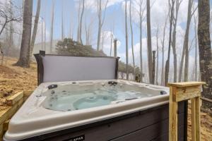 a jacuzzi tub in the middle of a forest at Skyledge in Beech Mountain