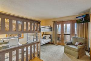 a baby room with a crib and a chair at Skyledge in Beech Mountain