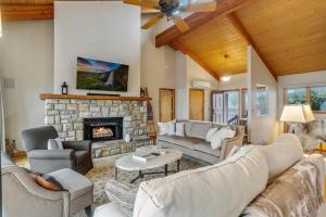 a living room with couches and a stone fireplace at Skyledge in Beech Mountain