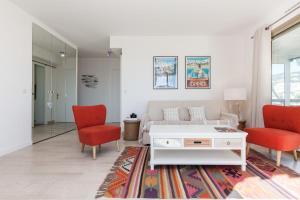 uma sala de estar com um sofá e duas cadeiras vermelhas em SERRENDY Sea view & terrace heart of Cannes em Cannes