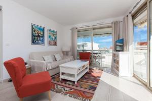 a living room with a couch and a table at SERRENDY Sea view & terrace heart of Cannes in Cannes