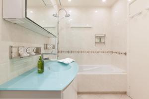 坎城的住宿－SERRENDY Sea View Cannes Croisette，浴室配有蓝色水槽和浴缸。