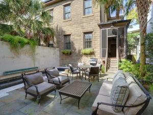 un patio con sillas y una mesa frente a un edificio en Southern Elegance Estate, en Savannah