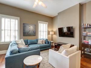 sala de estar con sofá azul y 2 sillas en Southern Elegance Estate, en Savannah