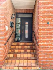 eine Eingangstür eines Backsteingebäudes mit einer Treppe in der Unterkunft Haus Tida in Norderney