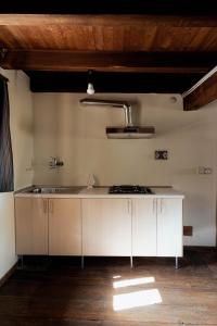 阿切廖的住宿－Visaisa taverna & foresteria，厨房配有白色橱柜和水槽
