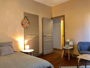 a bedroom with a bed and a clock on the wall at LE ORANGE - Confort - Wifi - Entre Gare et Centre in Quimper