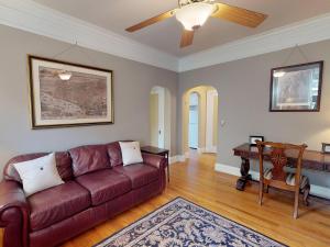 sala de estar con sofá marrón y piano en Southern Charm on Liberty, en Savannah