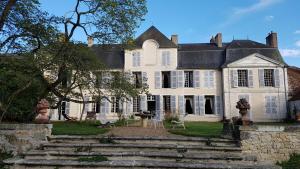 uma grande casa branca com escadas em frente em Chambre aux coccinelles em Cosne-Cours-sur-Loire