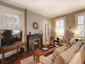 een woonkamer met een televisie en een open haard bij Luxury on Lincoln in Savannah