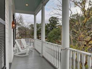 un porche con mecedoras blancas en una casa en Southern Exposure, en Savannah