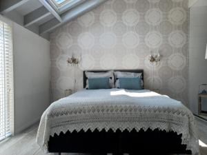 een slaapkamer met een groot bed met blauwe kussens bij Schaapskooi in Dwingeloo