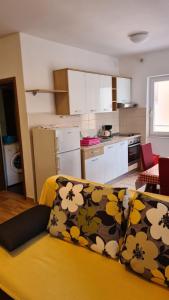 Apartments Ivanovski في راب: غرفة معيشة مع أريكة صفراء ومطبخ