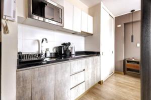 a kitchen with a sink and a microwave at Loft moderno en Barranco con piscina vista al mar in Lima